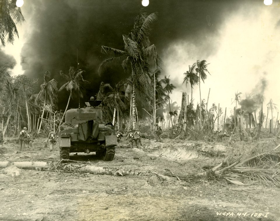Infantrymen advance aided by medium tank on Kwajalein. 1 F…