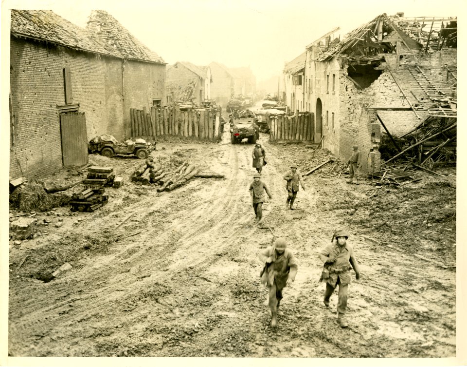 A small unit of American infantrymen advances double-time …