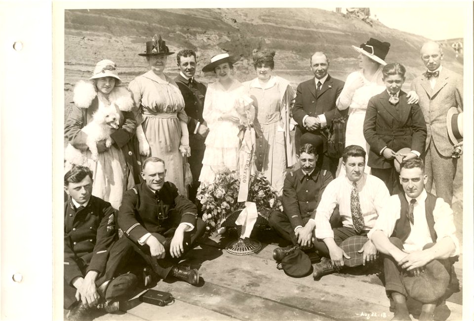 Unidentified men, women and dog on christening platform fo…