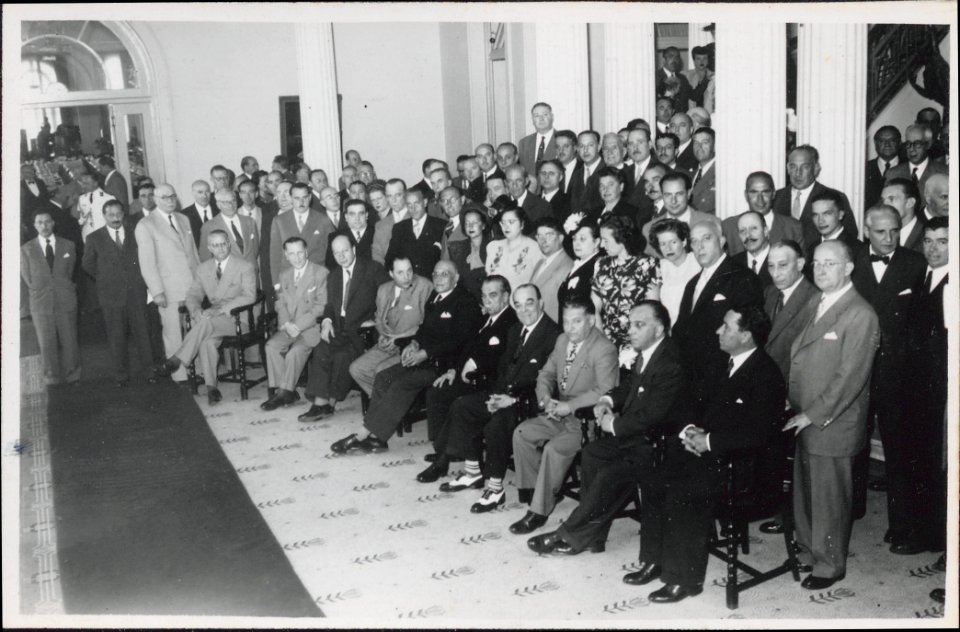"Manuel Blasco Garzón, retrato de grupo. En reverso: Algunos de los asistentes al acto. En primer término a la derecha el embajador de la URSS (sentado)"