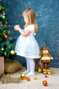 Girl decorates the christmas tree toys new christmas decorations photo