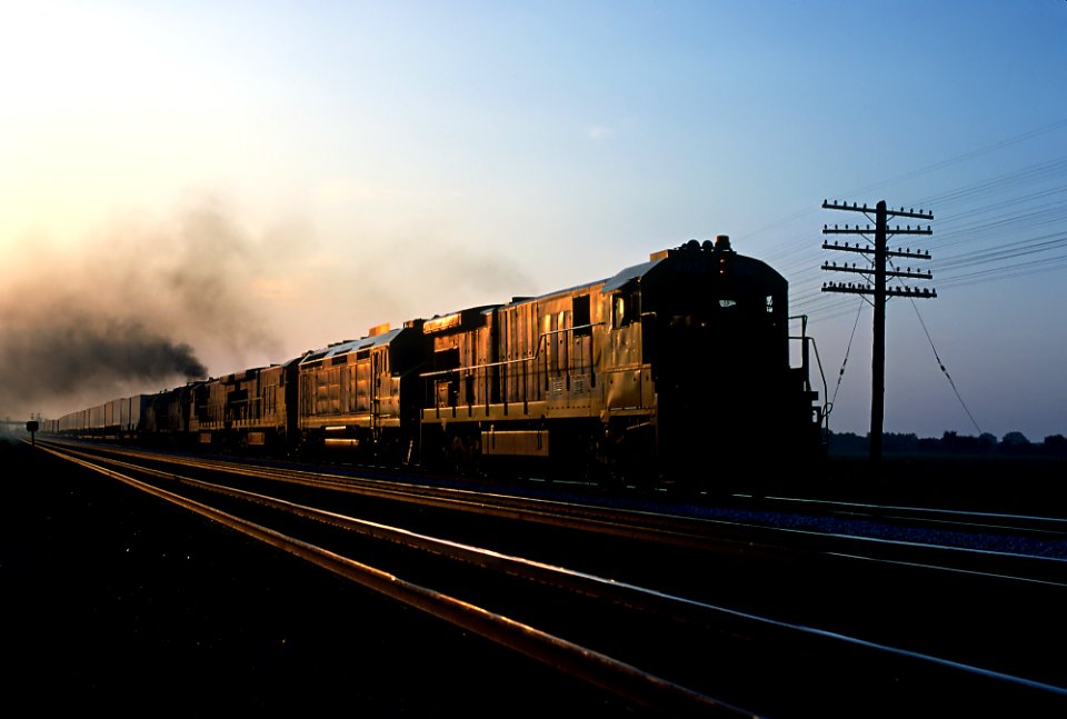 ATSF 8082 westbound early in the morning, taken at the Road F crossing about a mile west of the old Merrick interlocking tower on the west side of Emporia, KS in August 1983 (35979701241)