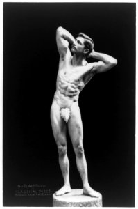 Nude male, Prof. B.A. McFadden, full-length portrait, standing on pedestal, facing left, wearing a fig leaf, with hands behind head LCCN97510663