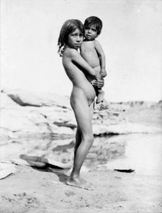 Nude pueblo Indian girl holding small child