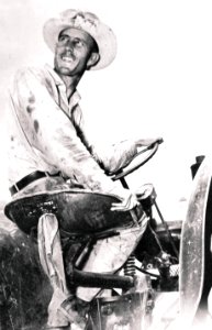 Orville Poddy surveys the wheat fields on his tractor during WWII (19357352684)
