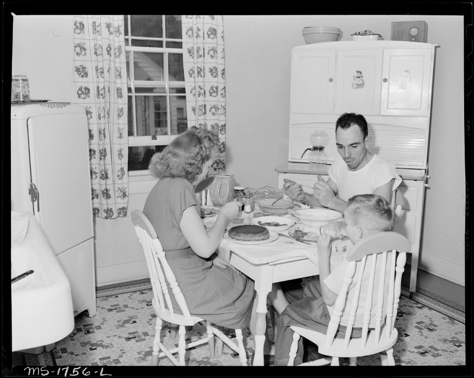 P.C. Goins, section foreman, and family eat dinner in kitchen in their home in company housing project. Koppers Coal... - NARA - 540917