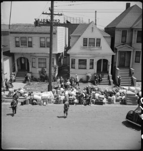 Oakland, California. Baggage of evacuees of Japanese ancestry piled on the sidewalk. The Greyhound . . . - NARA - 537701 photo