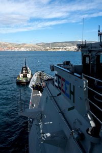 A tug boat pulls the guided missile cruiser USS Philippine Sea (CG 58) into Piraeus, Greece, for a scheduled liberty port visit March 4, 2014 140304-N-PJ969-257