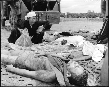A Vietnamese woman weeps over the body of her husband, one of the Vietnames Army casualties suffered in the war with... - NARA - 542295 photo