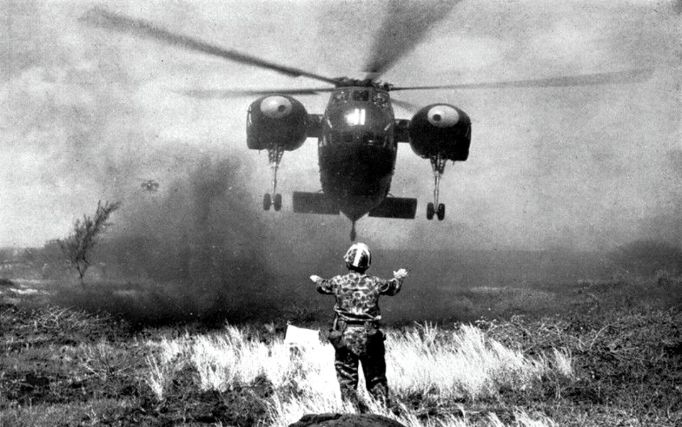 A U.S. Marine directs a Sikorsky HR2S-1 for a landing, in 1960