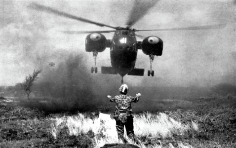 A U.S. Marine directs a Sikorsky HR2S-1 for a landing, in 1960