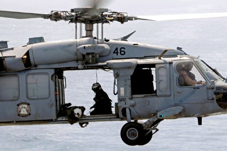 A U.S. Navy aircrewman checks the cargo pendant of an MH-60S Seahawk helicopter assigned to Helicopter Sea Combat Squadron (HSC) 23 during a vertical replenishment-at-sea between the fast combat support ship 110517-N-RC734-195