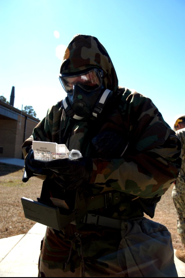 A U.S. Sailor with Naval Mobile Construction Battalion (NMCB) 25 prepares to test air quality with an M256 chemical agent detector kit during a simulated chemical attack during chemical, biological 140214-N-JP566-126