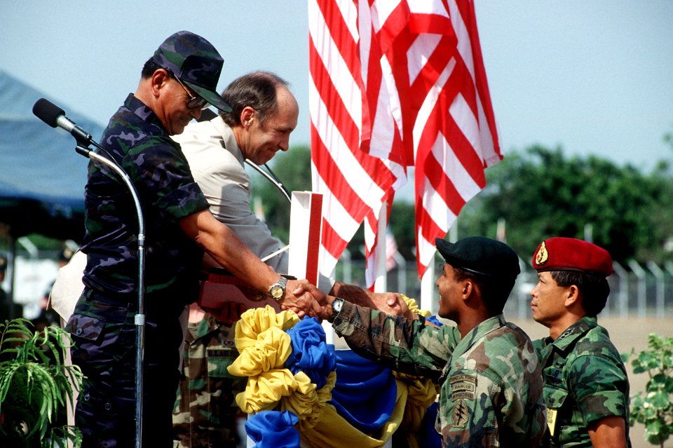 A U.S. soldier and a Thai soldier present gifts to Chief Marshal Kaset Rochananil and U.S. Ambassador David F. Lambertson during the opening ceremonies for the joint Thai-U.S. training exercise Cobra Gold '92