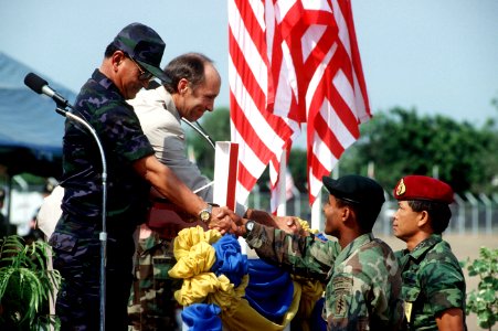 A U.S. soldier and a Thai soldier present gifts to Chief Marshal Kaset Rochananil and U.S. Ambassador David F. Lambertson during the opening ceremonies for the joint Thai-U.S. training exercise Cobra Gold '92 photo