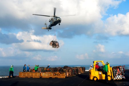 A U.S. Navy MH-60S Seahawk helicopter assigned to Helicopter Sea Combat Squadron (HSC) 7 delivers cargo to the aircraft carrier USS Harry S. Truman (CVN 75) during a replenishment at sea March 7, 2014, in 140307-N-ZG705-241