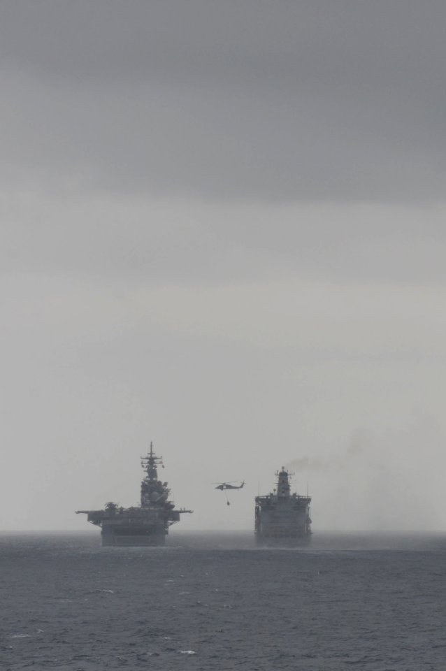 A U.S. Navy MH-60S Seahawk helicopter, assigned to Helicopter Sea Combat Squadron (HSC) 23, transports supplies from the fleet replenishment oiler USNS Rappahannock (T-AO 204) to the amphibious assault ship USS 110316-N-RC734-169