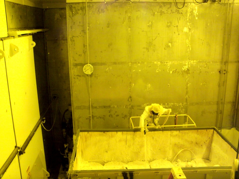 A waste disposition operator applies spray foam