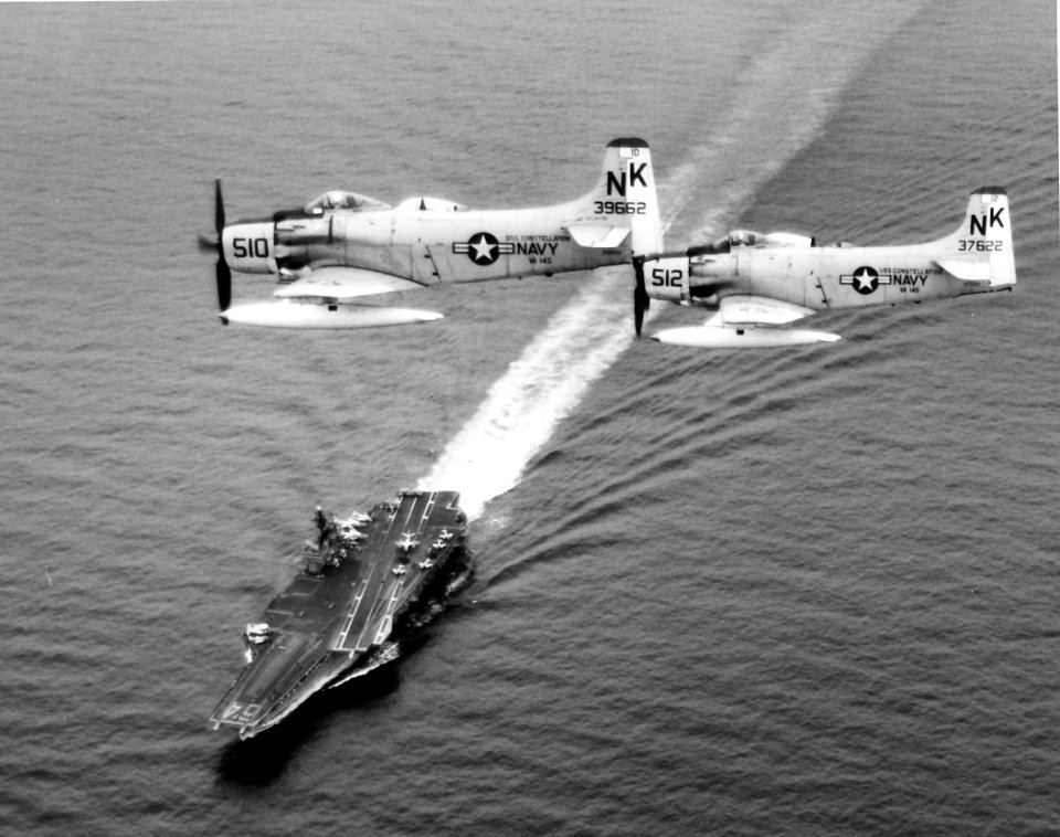 A-1H Skyraiders of VA-145 in flight over USS Constellation (CVA-64), circa 1964 (NNAM.1996.253.2786)