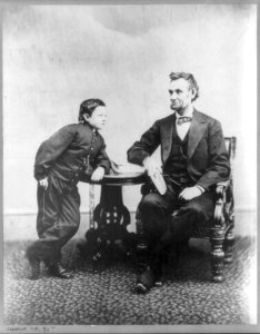 Abraham Lincoln, seated and holding a book, with his son Tad (Thomas) leaning on a table LCCN2007675781