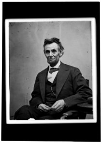 Abraham Lincoln, three-quarter length portrait, seated and holding his spectacles and a pencil LCCN98504569