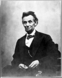 Abraham Lincoln, three-quarter length portrait, seated and holding his spectacles and pencil (retouched to stand out) LCCN2007675780