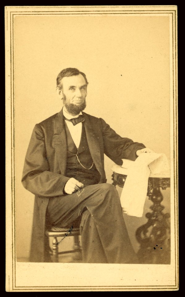 Abraham Lincoln, U.S. President. Seated portrait, holding glasses and newspaper, Aug. 9, 1863 LCCN2008680388