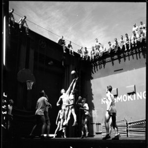 Activities aboard USS Monterey (CVL-26). Navy pilots in the forward elevator well playing basketball. - NARA - 520764 photo