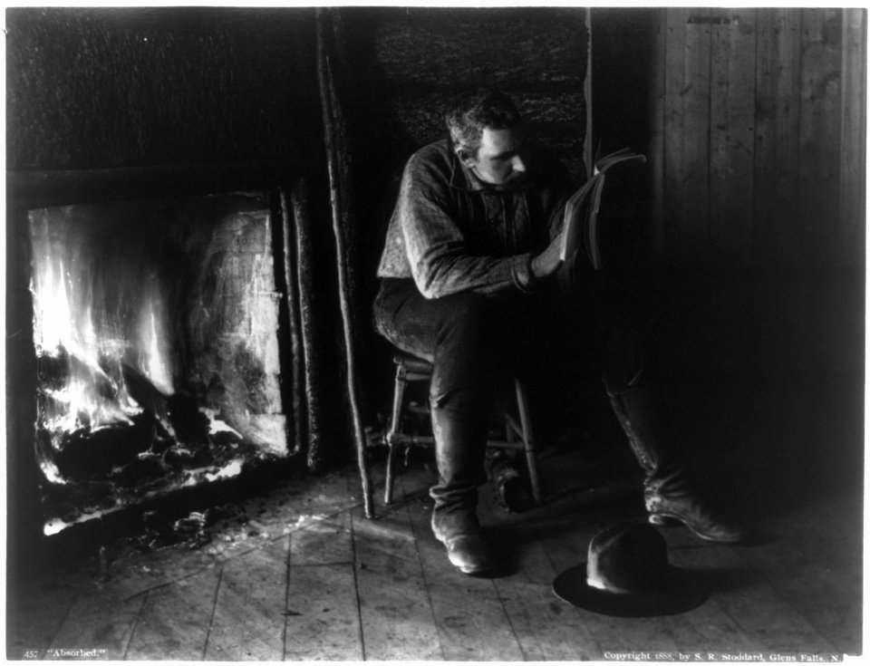 Adirondack Mountains, N.Y.- Absorbed - man reading by fireplace LCCN2003678344