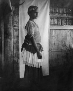 Adlig flicka i blå och vit kjol med huvudband av pärlor. Kulawi, Sulawesi. Indonesien - SMVK - 000233