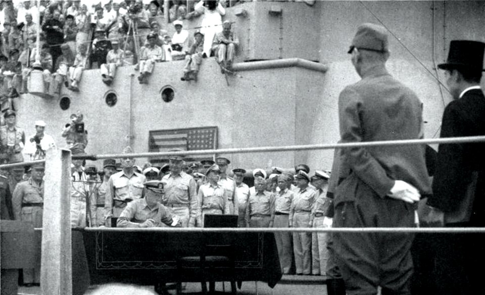 Admiral Chester W. Nimitz, USN, signs the Japanese surrender document aboard USS Missouri (BB-63) in Tokyo Bay on 2 September 1945