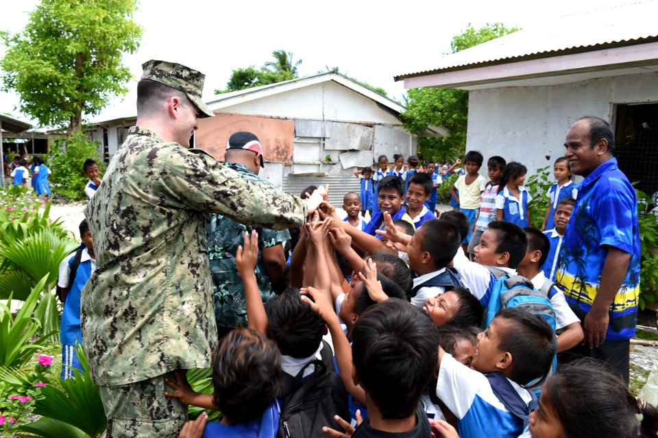 Advanced party engineer 'high fives' students at the Bikenibeu West Primary School 150519-N-HY254-035