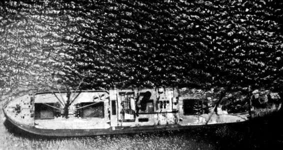 Aerial view of a Japanese freighter sinking off Okinawa c1945