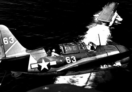 Aerial view of SB2C in upper landing circle showing USS YORKTOWN, below HD-SN-99-02622