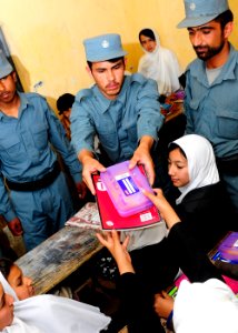 Afghan National Civil Order Police patrolmen hand out school supplies to students in a Kabul classroom. (4678254506) photo