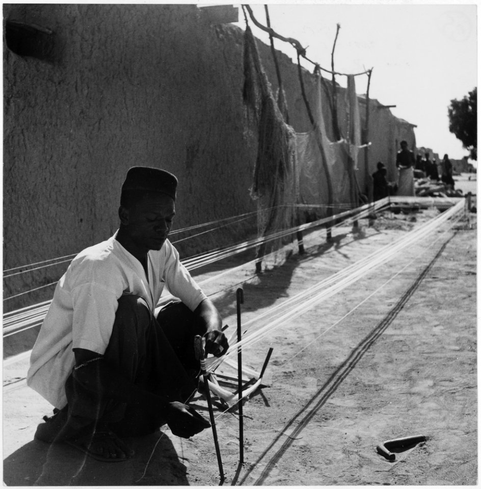 Africa. French West Africa. In the villiage of Niono, a native prepares thread - spun from locally-grown cotton - for... - NARA - 541638