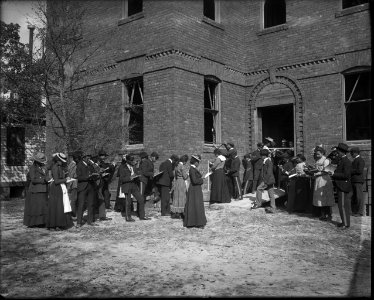 African American men and women students outside a brick building with notebooks at Tuskegee Normal and Industrial Institute, Alabama LCCN2017650161