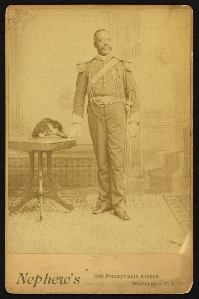 African American soldier, full-length portrait, wearing GAR medal, standing next to table) - Nephew's, 493 Pennsylvania Avenue, Washington, D. C LCCN2010645149