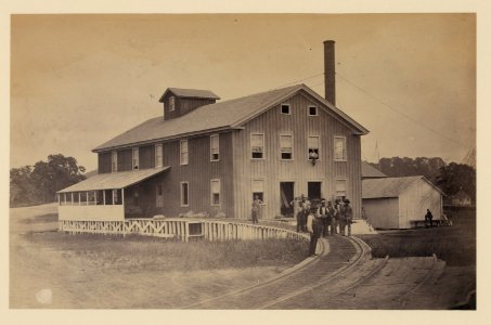 African American workers standing on railroad tracks in front of a storage facility, possibly at Giesboro cavalry depot LCCN2006683260