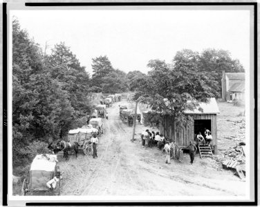 African Americans around small building and wagons loaded with cotton LCCN97507240