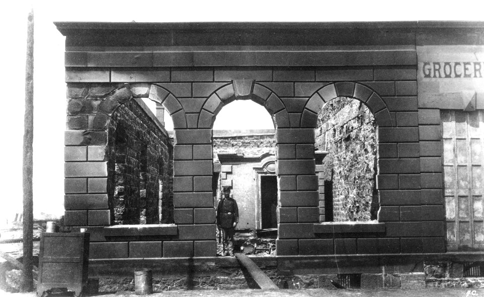 Aftermath of Seattle fire of June 6, 1889, showing remains of Dexter Horton & Co bank, 1st Ave S and S Washington St, with John (CURTIS 2104)