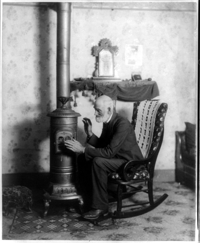 Aged man posed near a stove LCCN2004672300