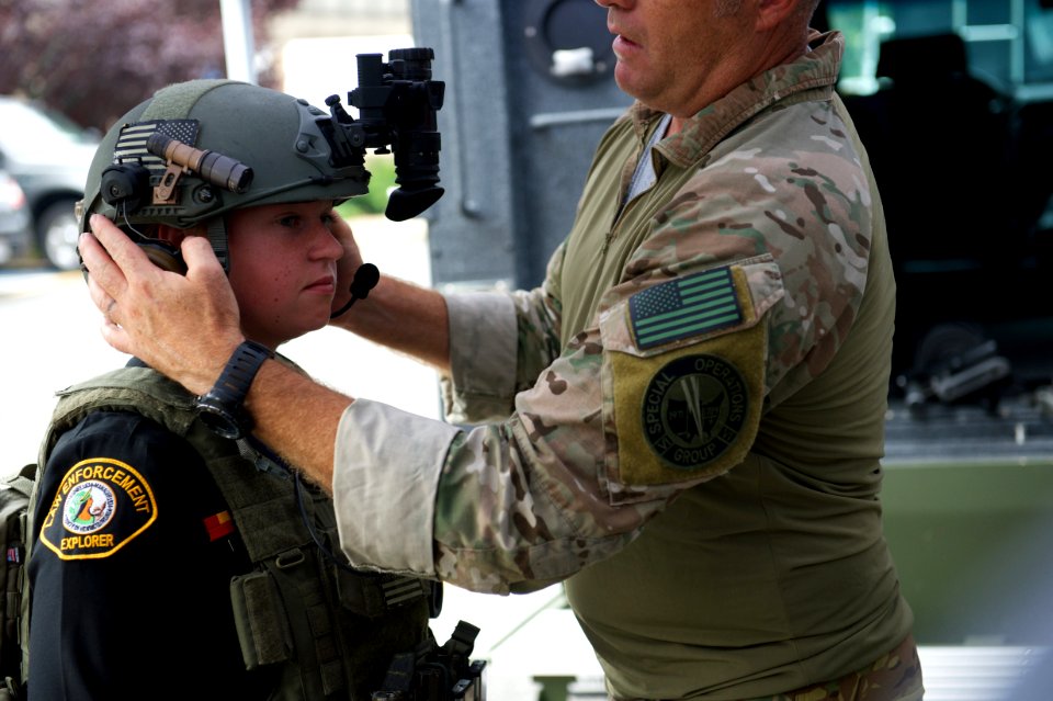 Agent helps law enforcement explorer try on helmet