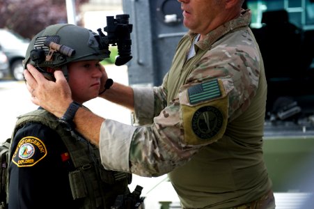 Agent helps law enforcement explorer try on helmet