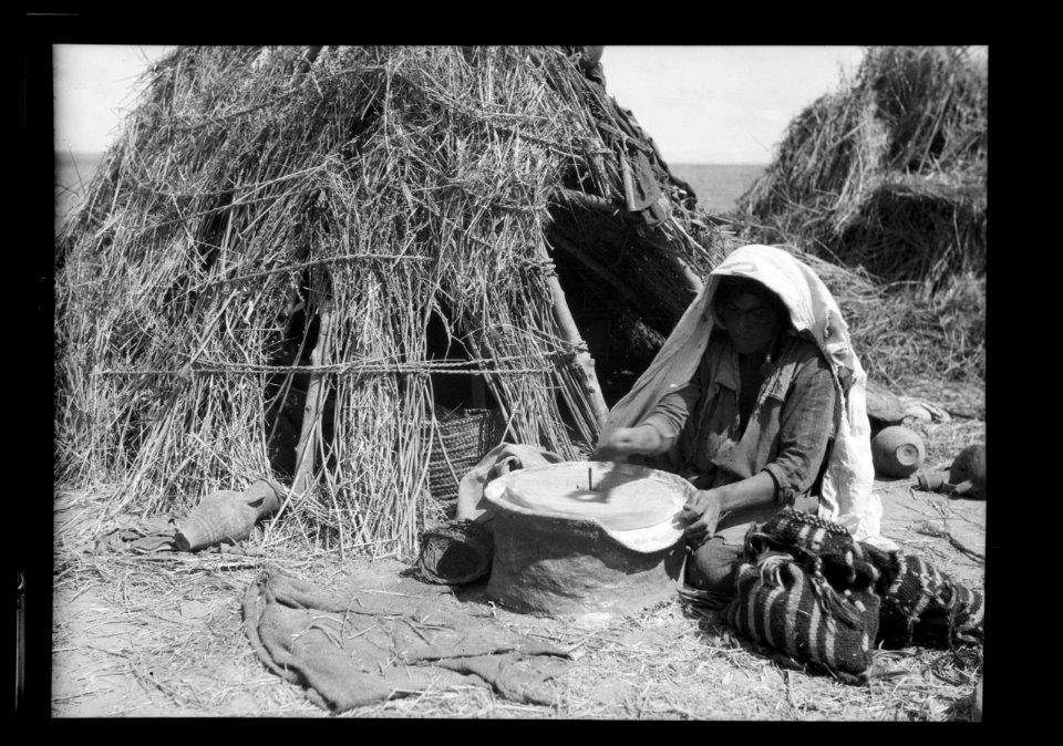 Agriculture, etc. Primitive methods of rubbing and grinding wheat. Woman grinding with present-day hand mill. Before her modest home on southern Sharon LOC matpc.15642