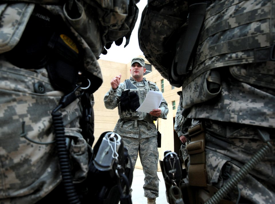 Air Guardsman discusses transportation information with a security detail inside the U.S. Embassy compound in Baghdad