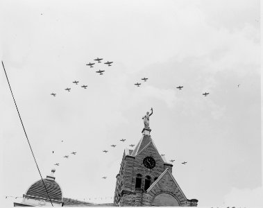 Airplanes passing over the county court house in Bolivar, Missouri, during ceremonies marking the presence in Bolivar... - NARA - 199901