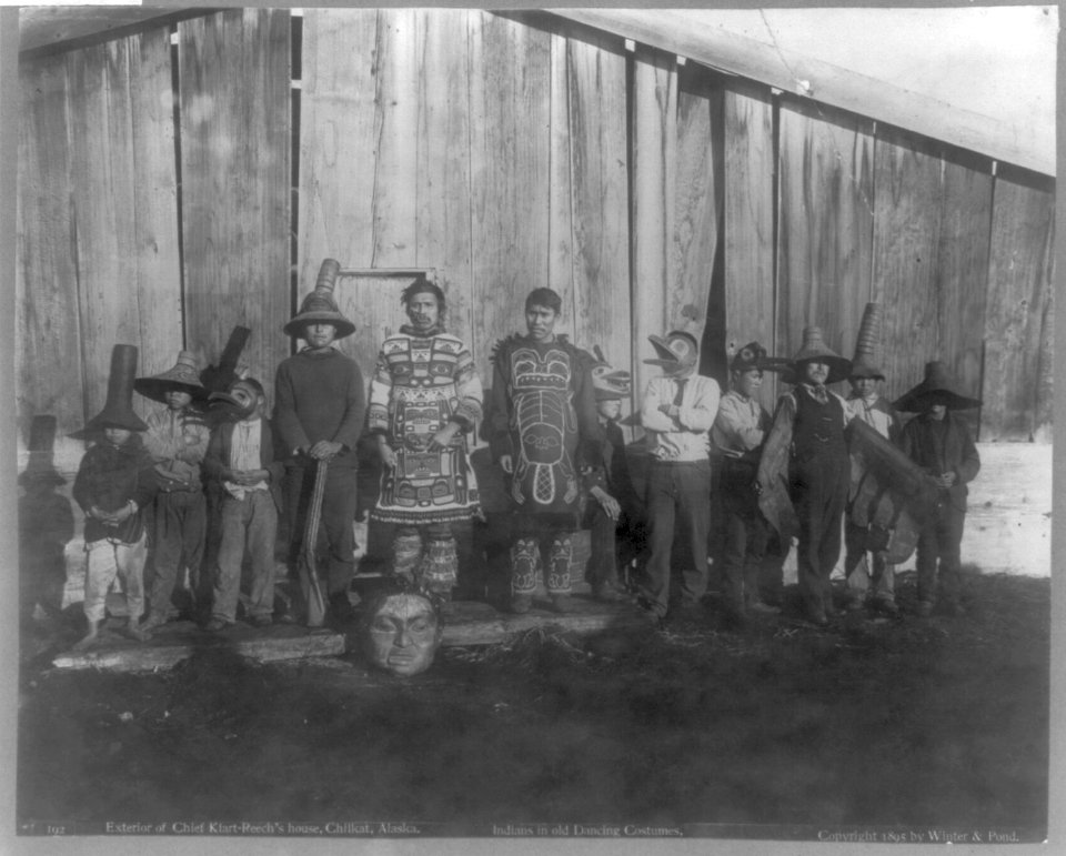 Alaskan Indians in old dancing costumes- group of 12 in front of Chief Klart-Reech's house, Chilkat LCCN2007680806