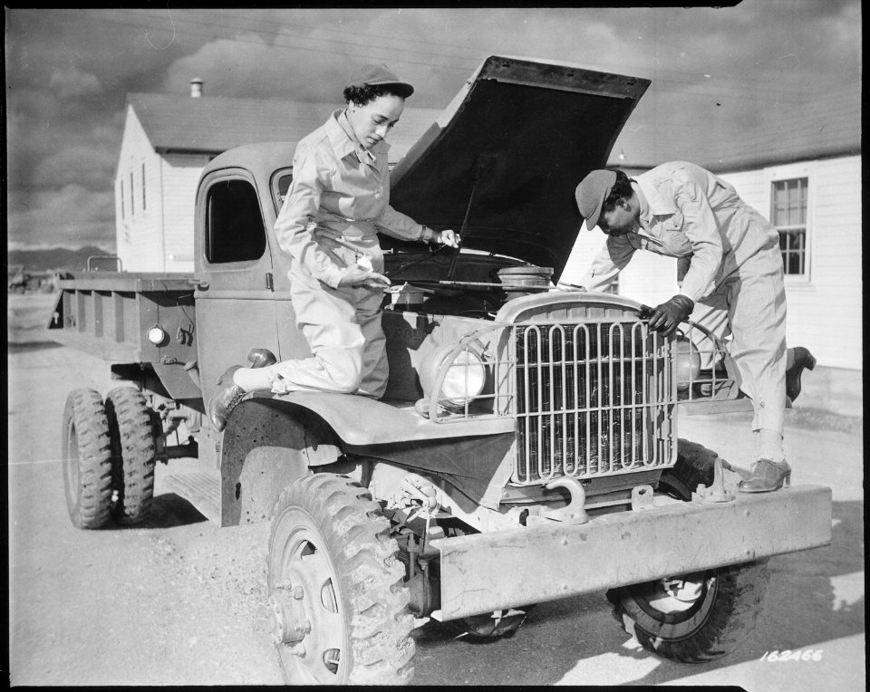 Auxiliaries Ruth Wade and Lucille Mayo (left to right) further demonstrate their ability to service trucks as taught th - NARA - 531153