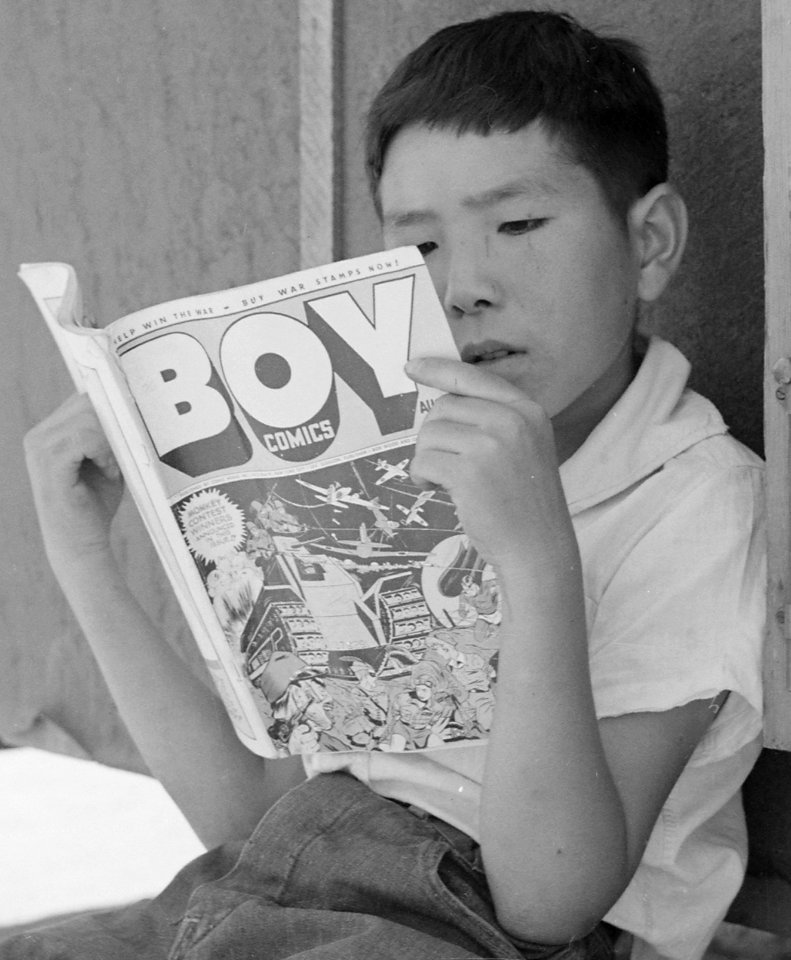BOY COMICS and boy face detail from- Manzanar Relocation Center, Manzanar, California. Evacuee boy at this War Relocation Authority cent . . . - NARA - 538076 (cropped)